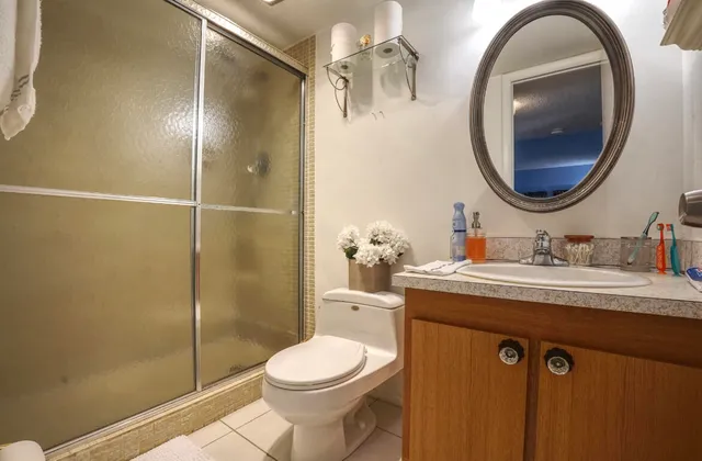 a bathroom with a granite countertop sink a toilet and a mirror