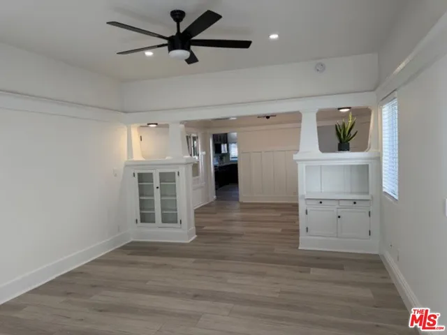 a view of a livingroom with wooden floor and a ceiling fan