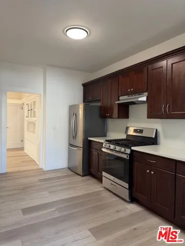 a kitchen with granite countertop wooden cabinets and stainless steel appliances