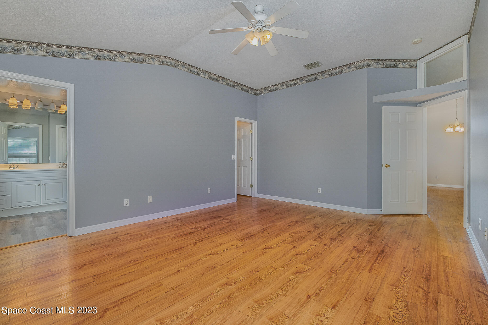 3910 La Flor Drive Rockledge, FL 32955 - Photo 14 of 24 a view of an empty room with wooden floor and a ceiling fan