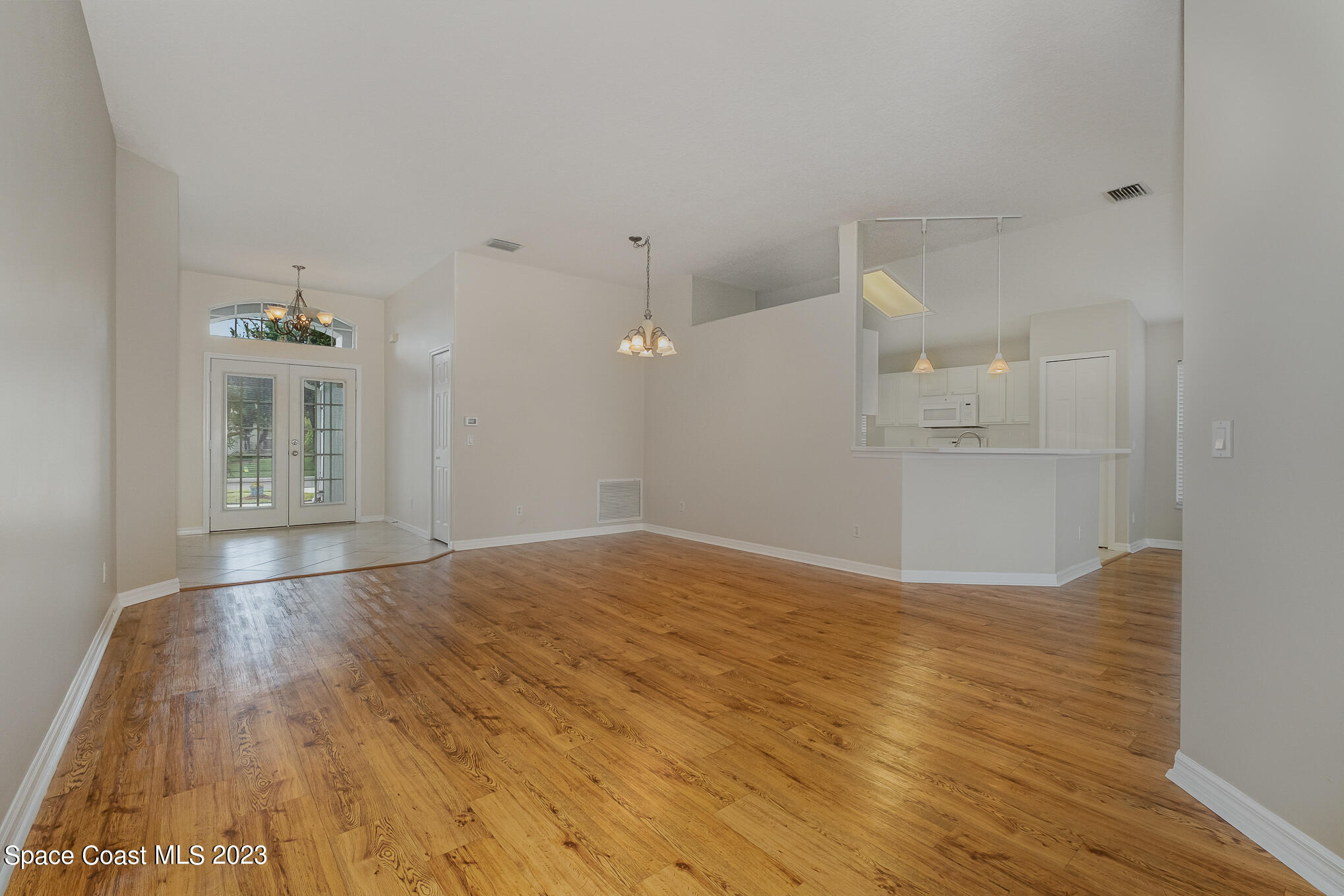 3910 La Flor Drive Rockledge, FL 32955 - Photo 3 of 24 a view of empty room with wooden floor and kitchen