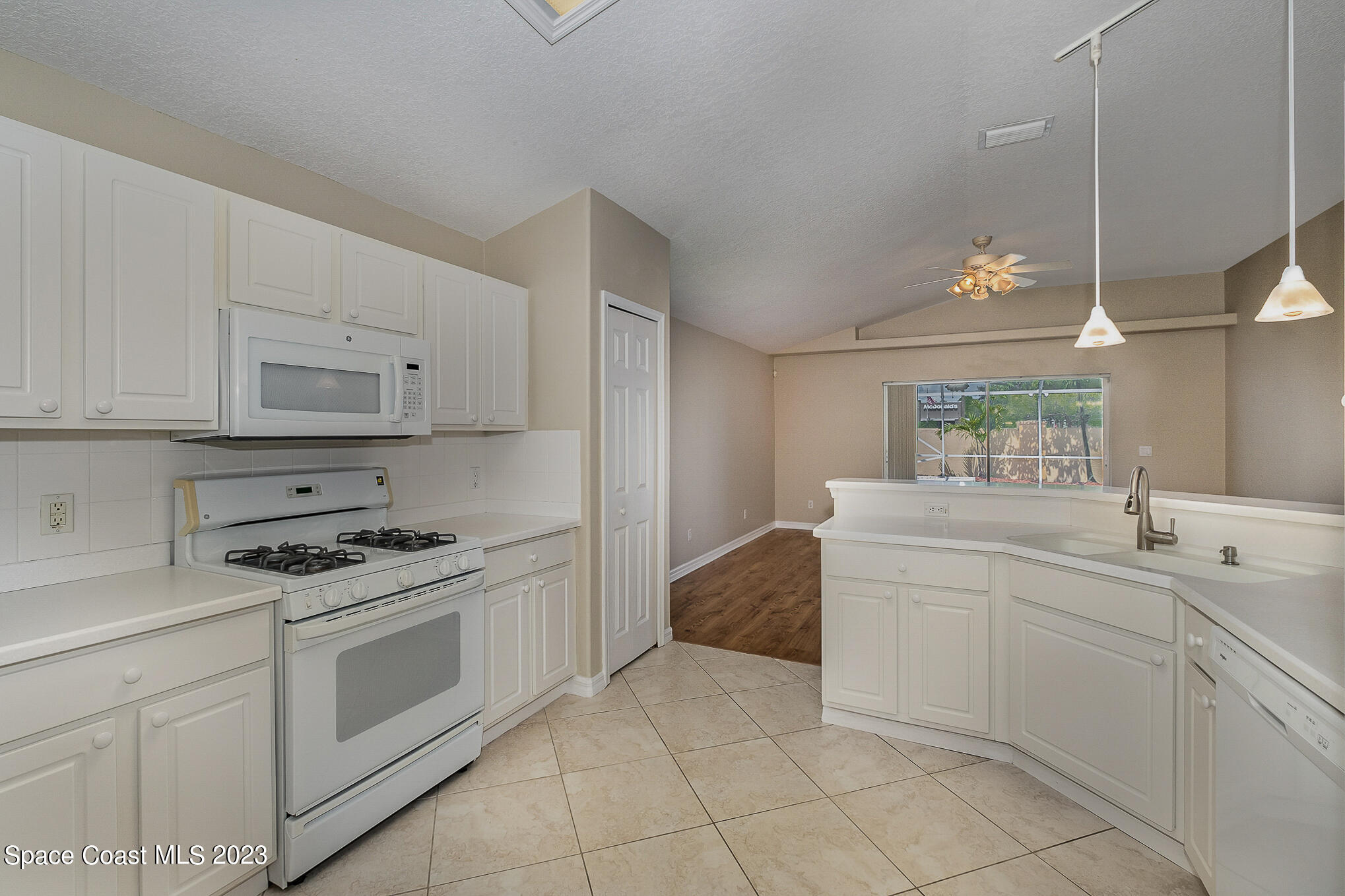 3910 La Flor Drive Rockledge, FL 32955 - Photo 10 of 24 a kitchen with white cabinets and white appliances