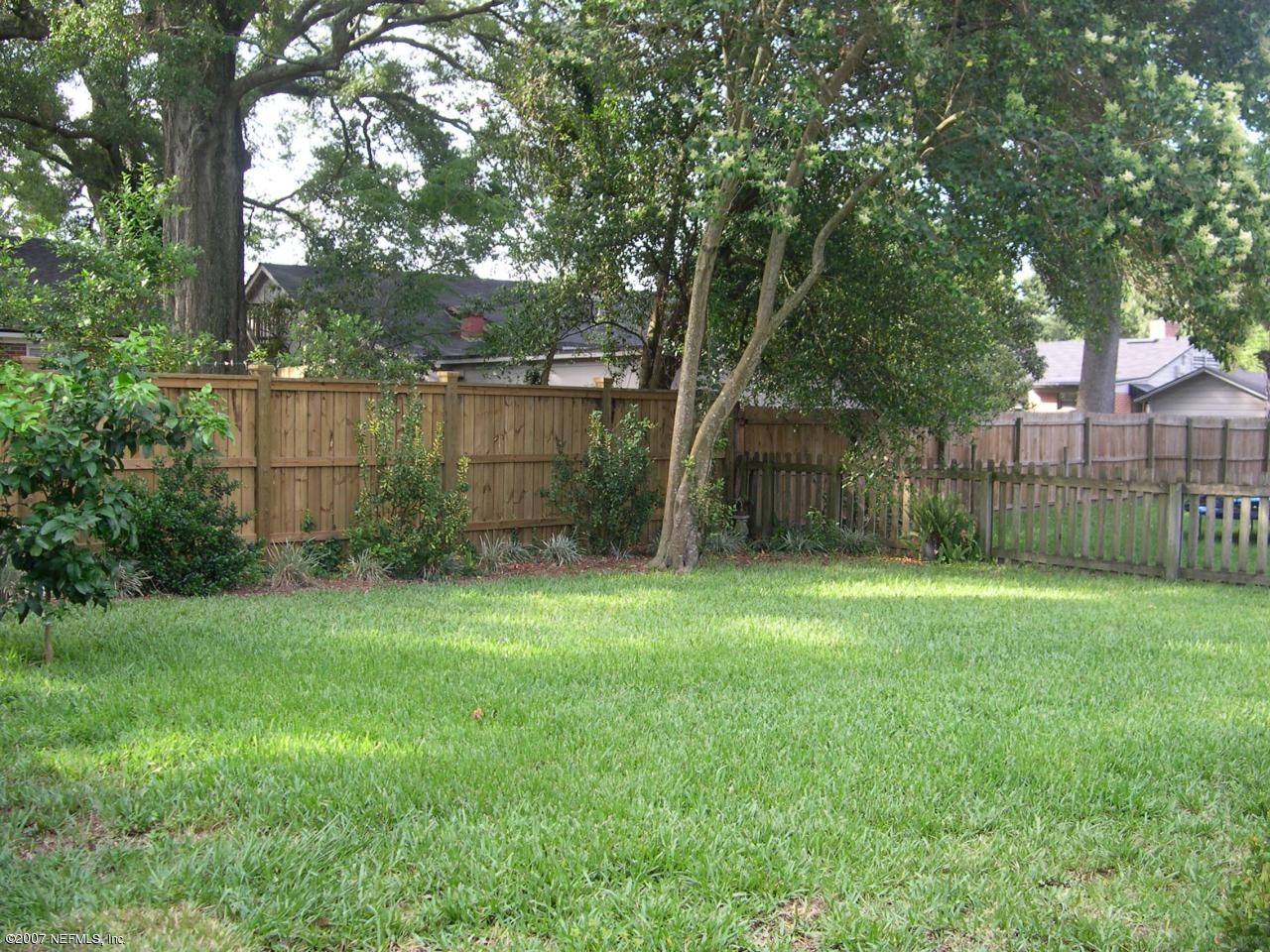 4145 London Road Jacksonville, FL 32207 - Photo 12 of 12 a view of a backyard with large trees and wooden fence