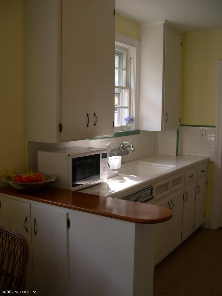 4145 London Road Jacksonville, FL 32207 - Photo 7 of 12 a kitchen with sink a microwave and cabinets