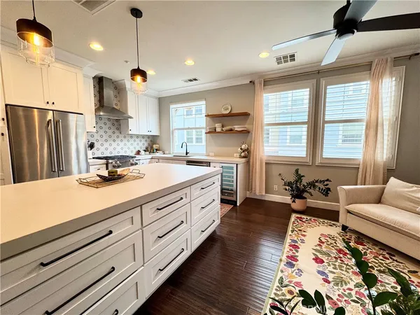 a large white kitchen with a large window a sink and stainless steel appliances