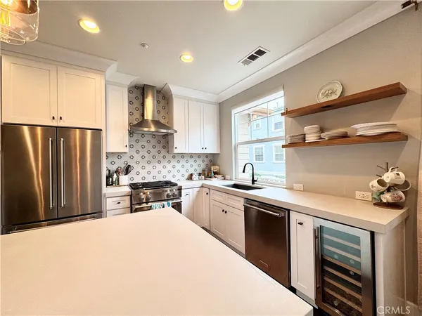 a kitchen with stainless steel appliances a sink stove refrigerator and cabinets