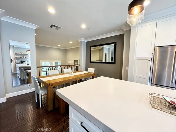 a kitchen with stainless steel appliances kitchen island granite countertop a refrigerator a stove and a sink with wooden floor