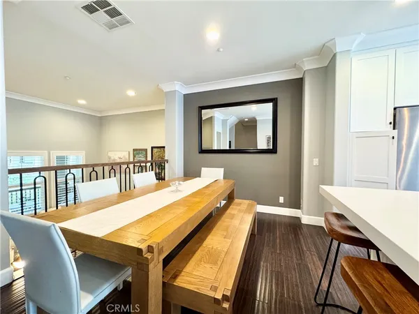 a dining room with wooden floor and furniture