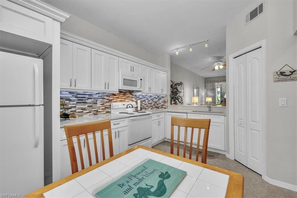 8075 Tiger Cove, Unit 1706 Naples, FL 34113 - Photo 14 of 50 a kitchen with stainless steel appliances granite countertop a refrigerator and a stove top oven