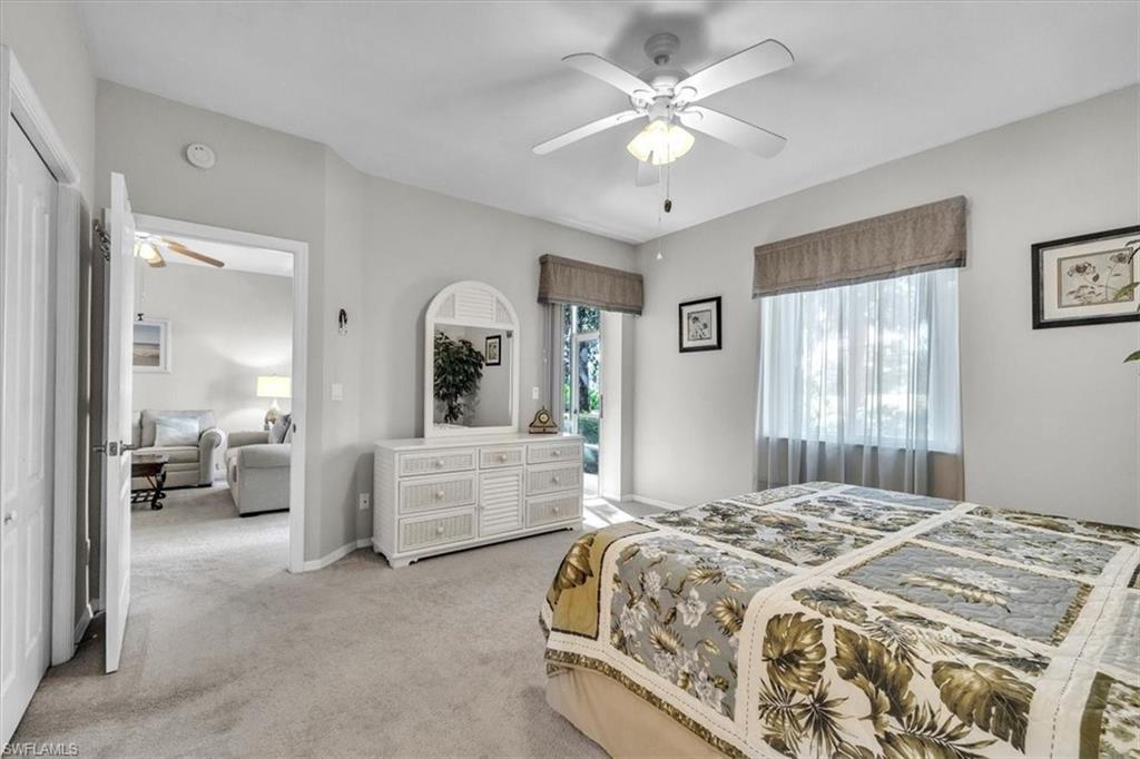 8075 Tiger Cove, Unit 1706 Naples, FL 34113 - Photo 17 of 50 a spacious bedroom with a large bed and a chandelier