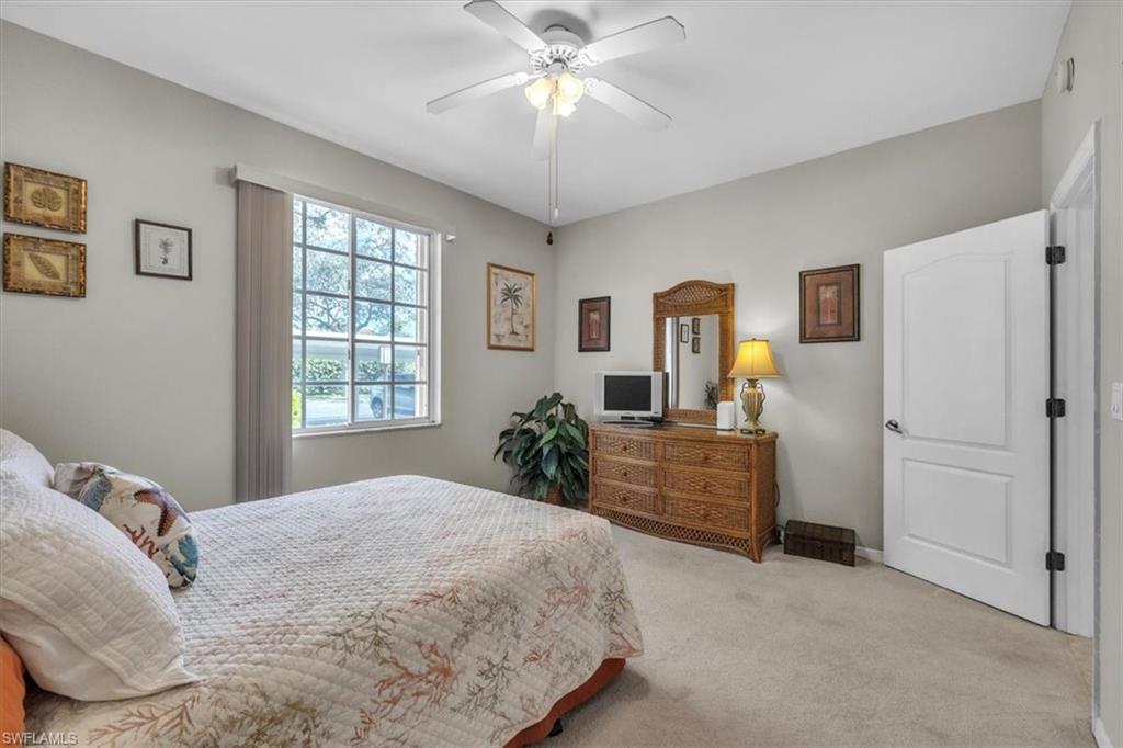 8075 Tiger Cove, Unit 1706 Naples, FL 34113 - Photo 29 of 50 a bedroom with a bed and a chandelier