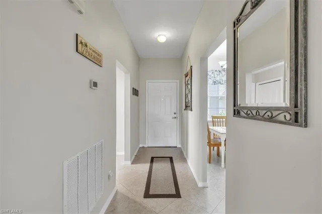a view of a hallway with wooden floor and a bathroom