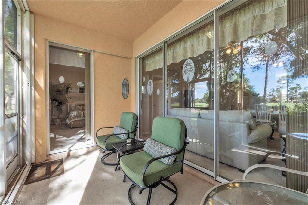 8075 Tiger Cove, Unit 1706 Naples, FL 34113 - Photo 34 of 50 a living room with furniture and a floor to ceiling window