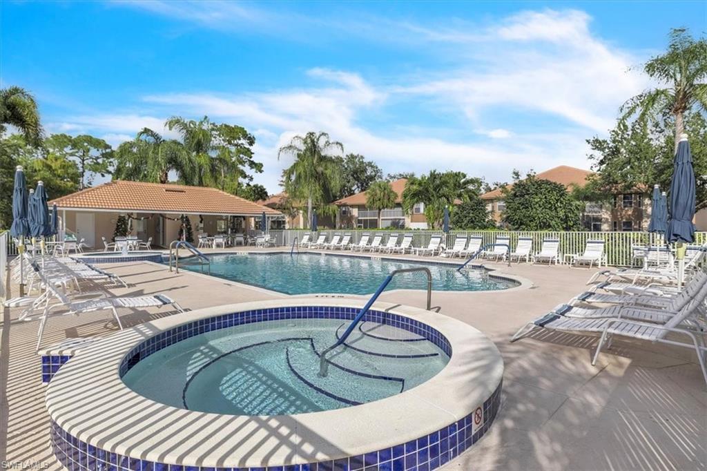8075 Tiger Cove, Unit 1706 Naples, FL 34113 - Photo 43 of 50 a swimming pool with outdoor seating and barbeque oven