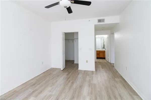 a view of a room with wooden floor and ceiling fan