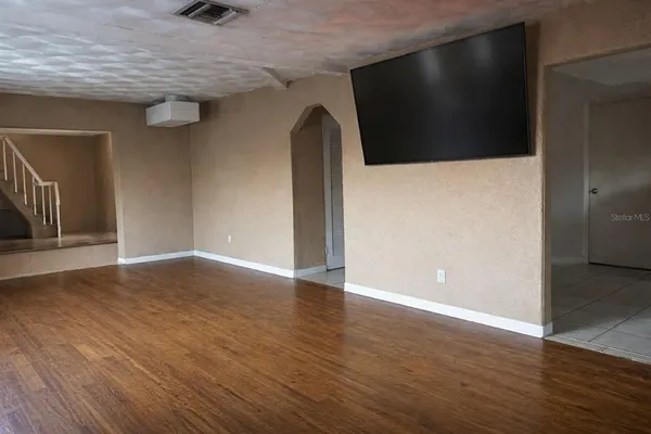 a view of empty room with wooden floor