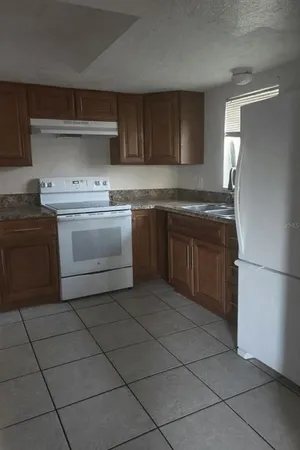 a kitchen with a stove sink and a refrigerator