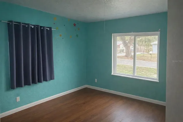 a view of a room with wooden floor and a window