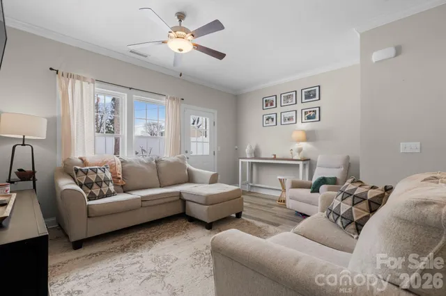 a living room with furniture ceiling fan and a window