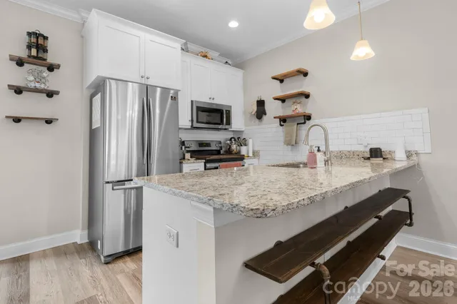 a kitchen with stainless steel appliances granite countertop a sink refrigerator and microwave