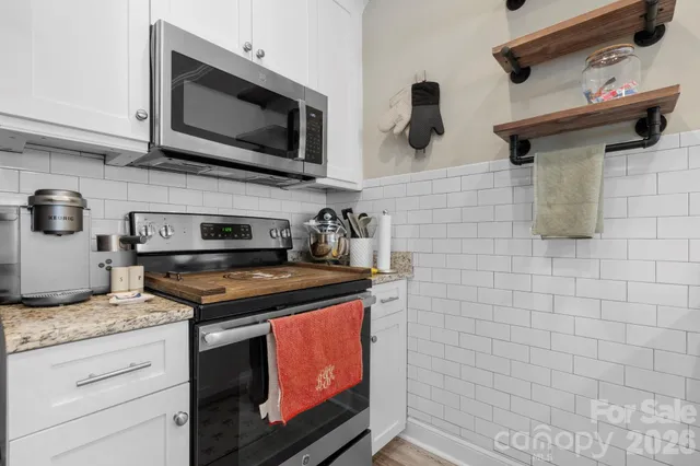 a kitchen with stainless steel appliances granite countertop a stove and a microwave
