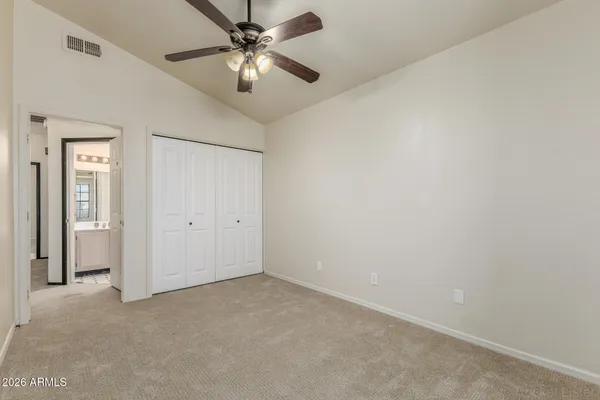 an empty room with windows and fan