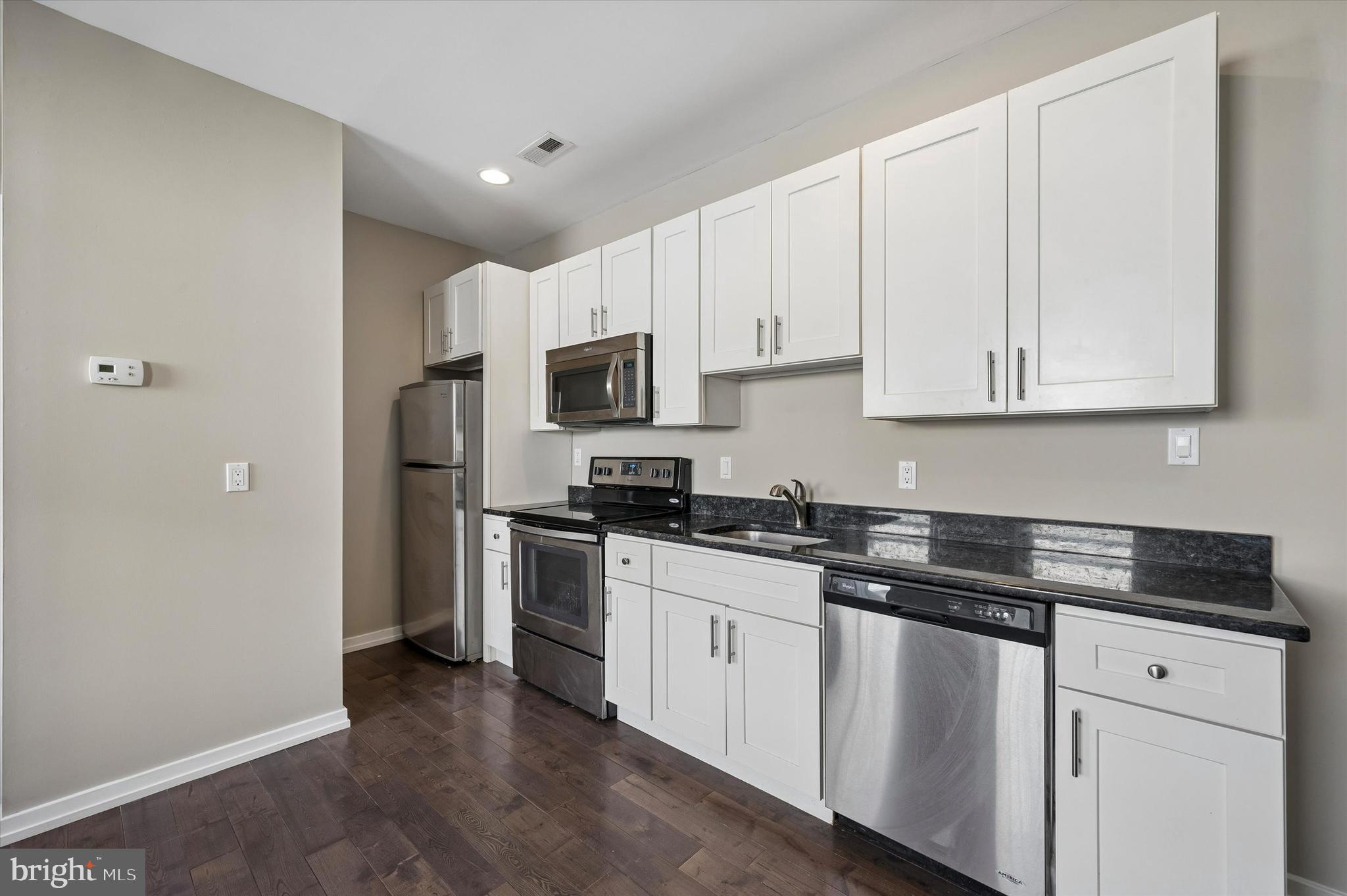 617 South 2nd Street, Unit 3R Philadelphia, PA 19147 - Photo 5 of 19 a kitchen with granite countertop white cabinets sink and stainless steel appliances