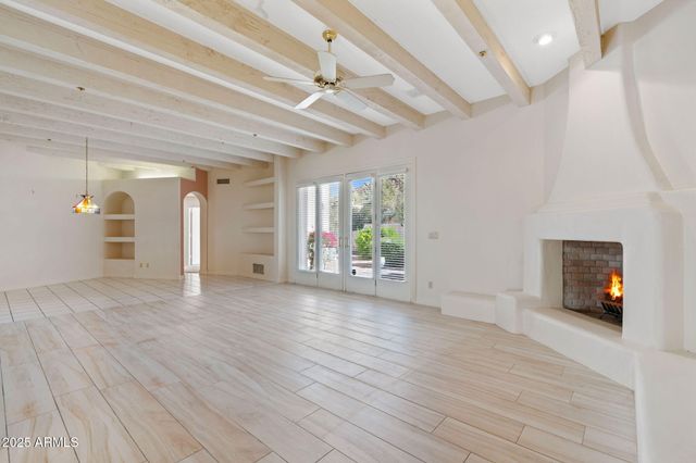 a view of a livingroom with wooden floor and a ceiling fan