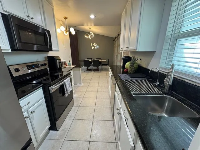 a kitchen with a sink a stove and cabinets