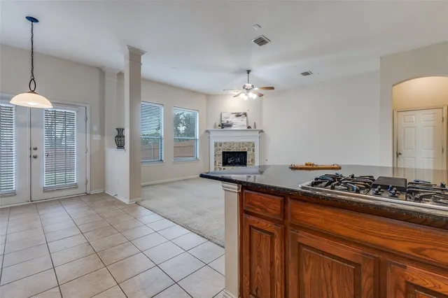 a kitchen with stainless steel appliances granite countertop a stove a sink dishwasher and a refrigerator with wooden cabinets