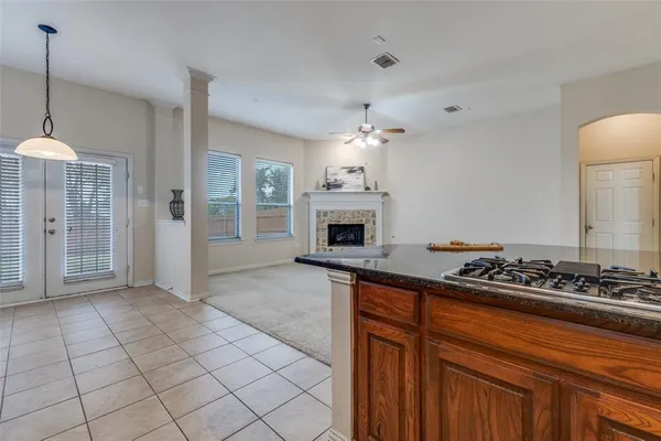 a kitchen with stainless steel appliances granite countertop a stove a sink dishwasher and a refrigerator with wooden cabinets