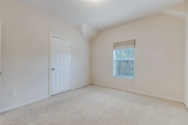 a view of an empty room with a chandelier fan
