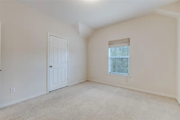 a view of an empty room with a chandelier fan
