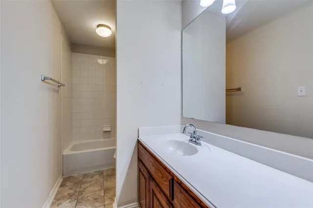 an empty room with chandelier fan and windows