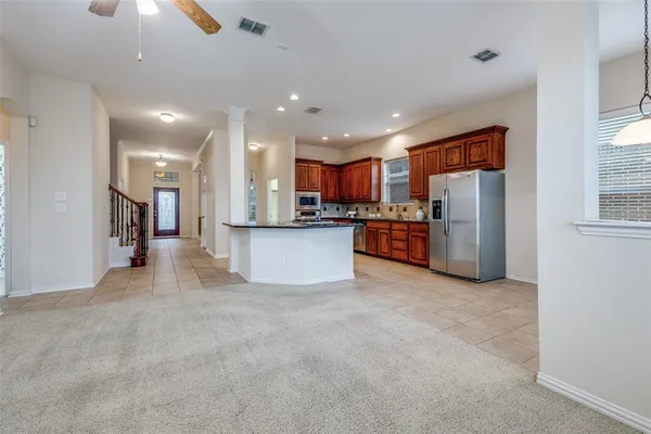 a view of a kitchen with a refrigerator a microwave and a sink