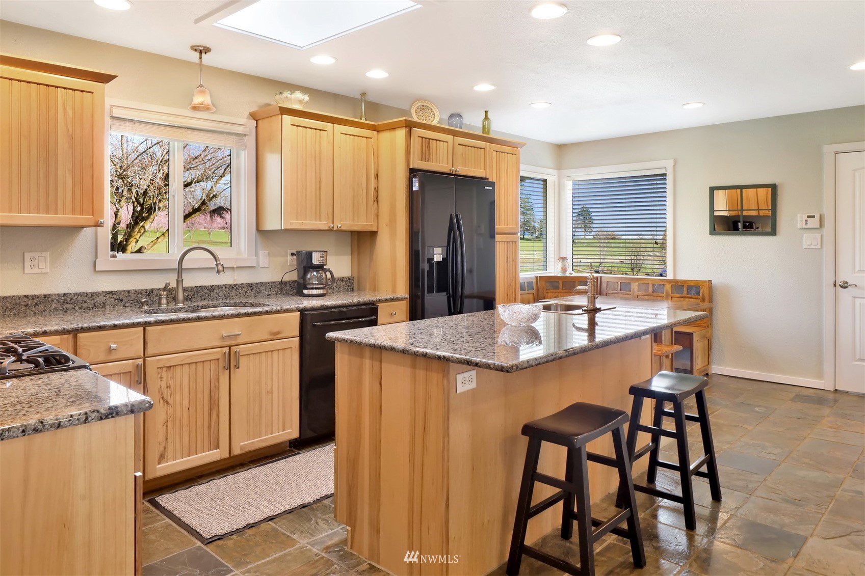 5397 Olson Road Ferndale, WA 98248 - Photo 6 of 40 a kitchen with a table chairs sink refrigerator and cabinets