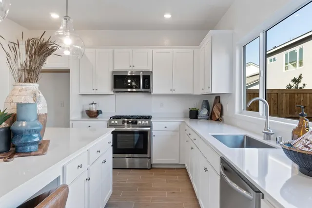 a kitchen with stainless steel appliances granite countertop a sink a stove and a refrigerator