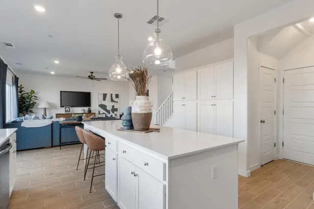 a kitchen with stainless steel appliances kitchen island granite countertop a sink and a refrigerator