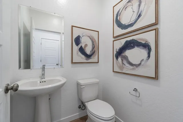 a bathroom with a toilet a sink and mirror