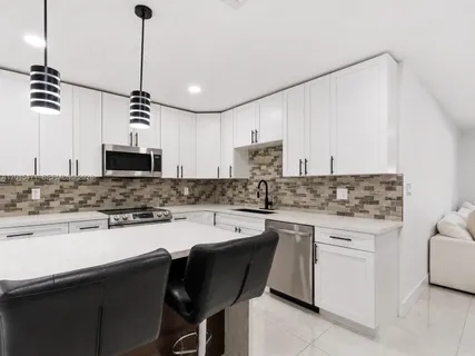 a kitchen with a sink stove and white cabinets