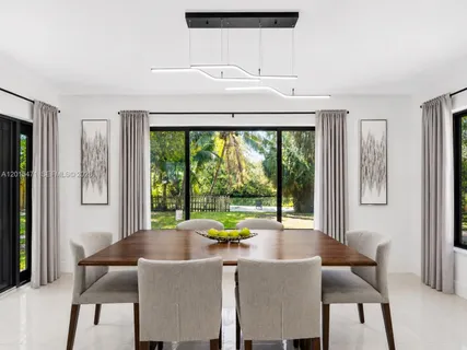 a dining room with furniture and a large window