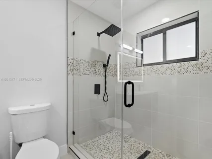 a bathroom with a shower a toilet and sink