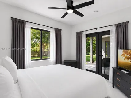 a bedroom with a large bed and a flat tv screen