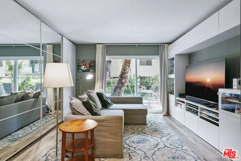 a living room with furniture a flat screen tv and a large window