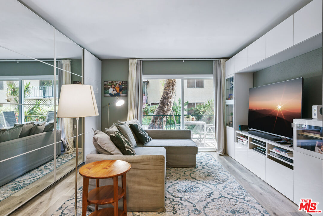 5460 White Oak Avenue, Unit A122 Encino, CA 91316 - Photo 3 of 19 a living room with furniture a flat screen tv and a large window
