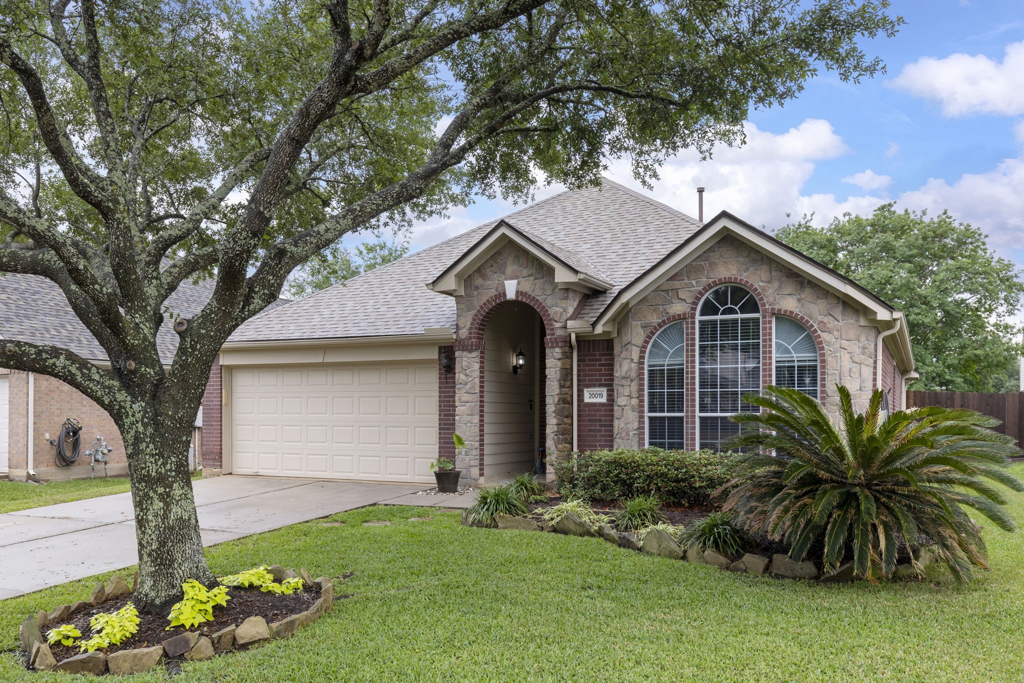 20019 Hardsville Drive Spring, TX 77388 - Photo 2 of 28 a front view of a house with a garden and plants