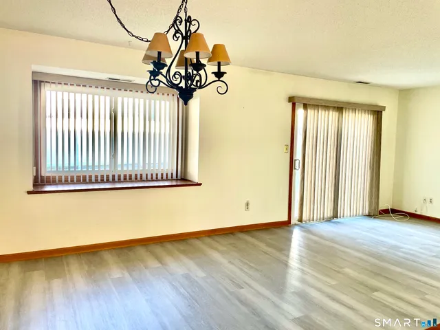 a view of a room with wooden floor and chandelier