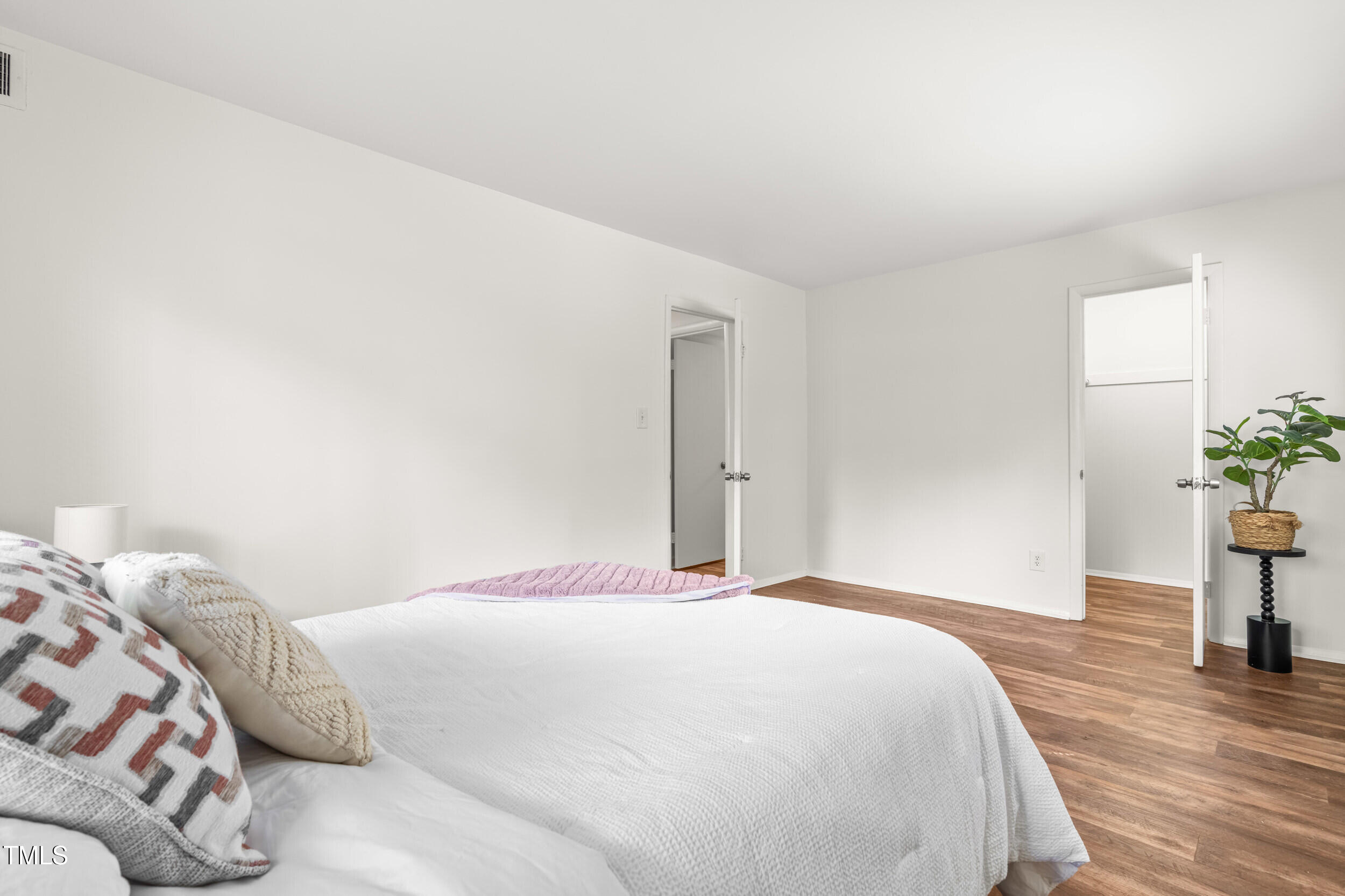 1212 Schaub Drive, Unit C Raleigh, NC 27606 - Photo 21 of 23 a bedroom with a bed and a potted plant
