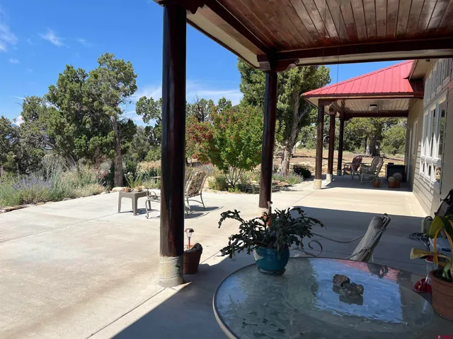 a view of a patio with a table and chairs under an umbrella