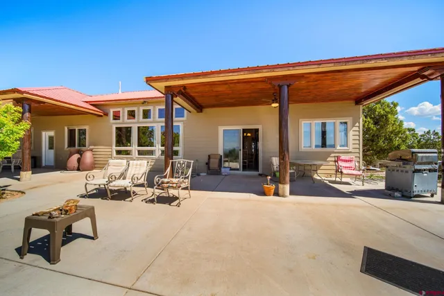 a view of a patio with dining table and chairs under an umbrella